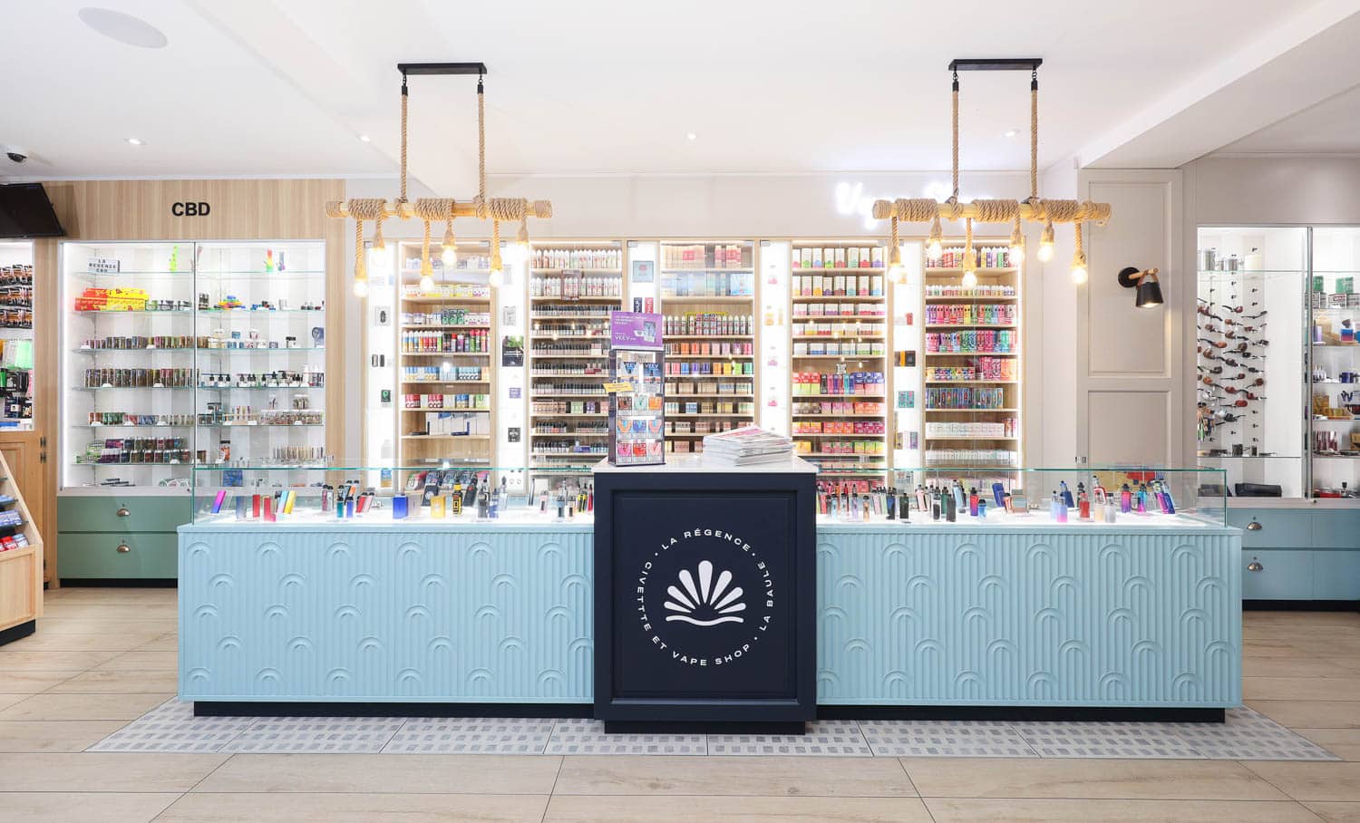 La Régence : comptoir bleu clair et linéaires lumineux La Régence : comptoir bleu clair et linéaires lumineux – Studio Kan